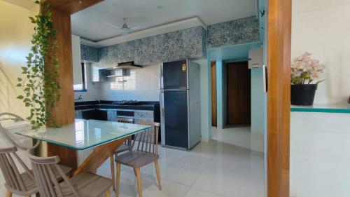 a kitchen with a glass table and chairs at The ten - one room in 3bhk in Pune