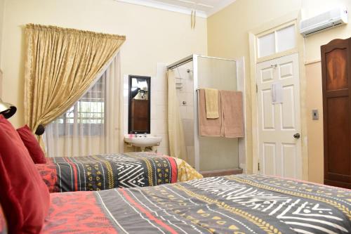 a bedroom with two beds and a bathroom with a sink at kestell Hotel in Kestell