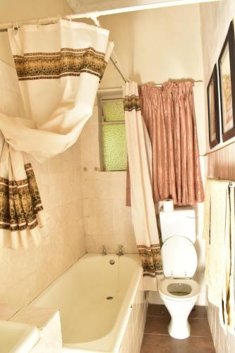 uma casa de banho com uma banheira branca e um WC. em kestell Hotel em Kestell