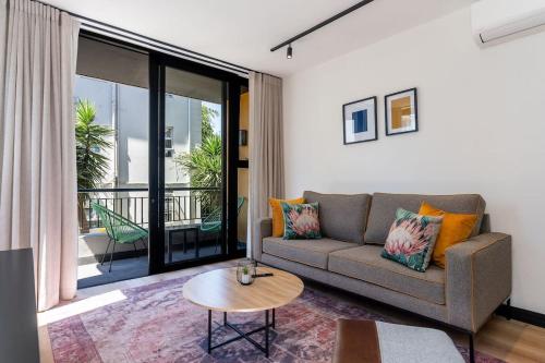 a living room with a couch and a table at Sea Point - 17 Hall Rd,204 - Modern 1 Bedroom Apartment with Free Onsite Parking in Cape Town