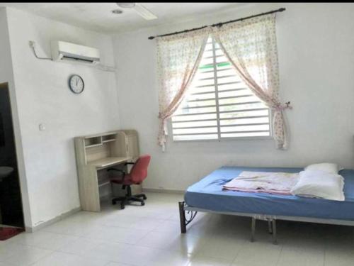 Schlafzimmer mit einem Bett, einem Schreibtisch und einem Fenster in der Unterkunft OYO Home 90977 AzZinki Homestay in Cukai
