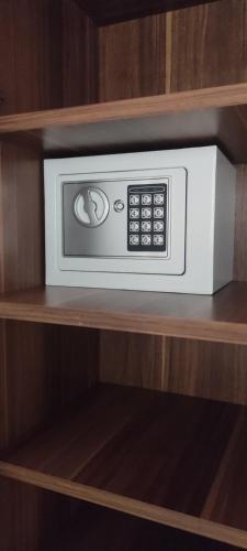 a white microwave on a shelf in a cabinet at Apartmani Kačara in Sremski Karlovci
