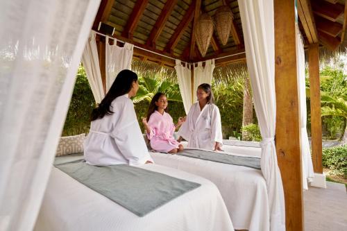 a group of three women in robes sitting on beds at Nickelodeon Hotels & Resorts Punta Cana - Gourmet All Inclusive by Karisma in Punta Cana