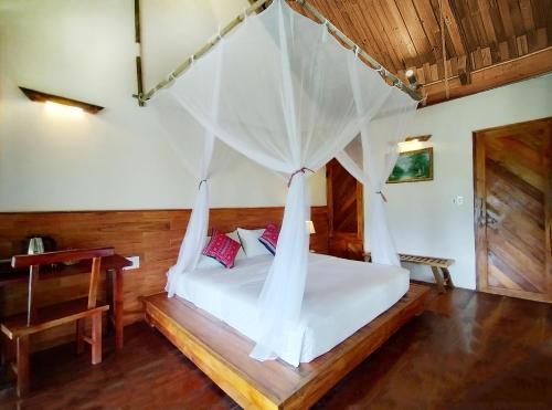 a bedroom with a bed with a mosquito net at PU LUONG BOUTIQUE GARDEN in Pu Luong