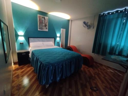sypialnia z łóżkiem i niebieską ścianą w obiekcie Hostal El Pilar w mieście Lima