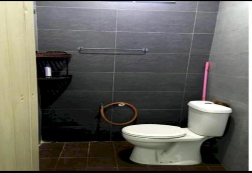 ein Bad mit einem WC und einem rosa Mopp in der Unterkunft OYO Home 90977 AzZinki Homestay in Cukai