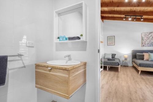 La salle de bains est pourvue d'un lavabo et d'un canapé. dans l'établissement Recharge in Waurn Ponds, à Geelong