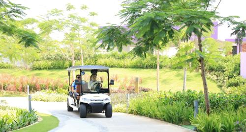 a golf cart driving down a road at TTC Van Phong Bay Resort - Himalaya Sauna & Steam Retreat Included in Ninh Hòa