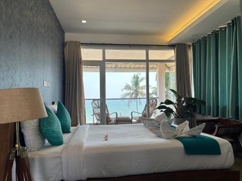 1 dormitorio con 1 cama y vistas al océano en Santa Maria, Trivandrum - An Airport Boutique by the Sea en Thiruvananthapuram