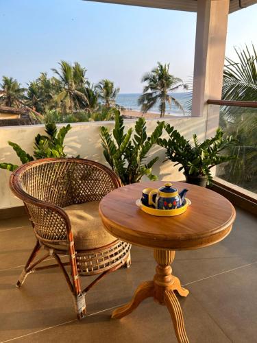a table and a chair with a bowl on it at Santa Maria, Trivandrum - An Airport Boutique by the Sea in Trivandrum