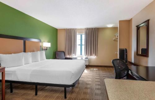 a hotel room with a large bed and a desk at Relax Suites Extended Stay - La Mirada in La Mirada