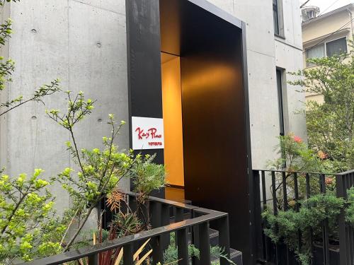 an entrance to a building with an orange door at Ken's Place四谷 in Tokyo