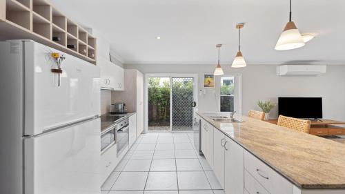 a kitchen with white appliances and a counter top at Aqua Links 70 The Drive Yamba in Yamba