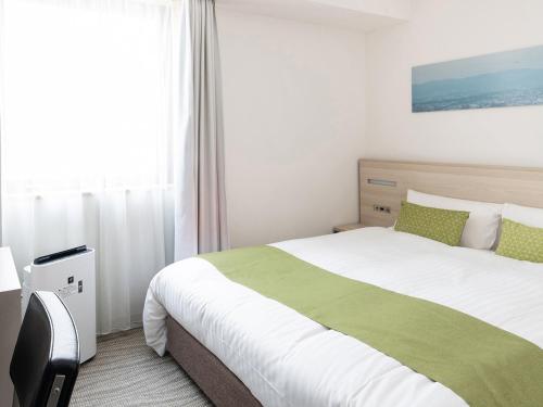a bedroom with a large bed and a window at Vessel Inn Shinsaibashi in Osaka
