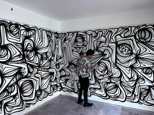 um homem parado em frente a uma parede a preto e branco em Art Apartment em Santiago