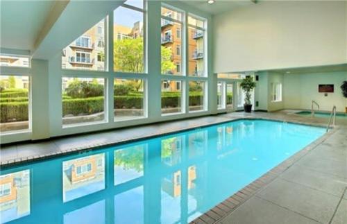 a large swimming pool in a large building at DT Designer's 2BR Condo Parking Tub Pool - 99 walk score in Seattle