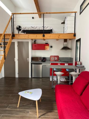 un salon avec un canapé rouge et une cuisine dans l'établissement DUPLEX de 40 m2 près d'une rivière, à Saint Alban Auriolles