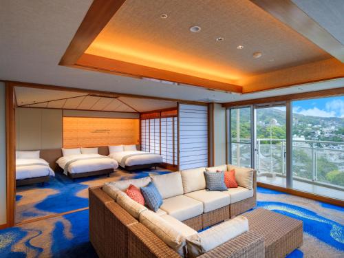 ein Wohnzimmer mit einem Sofa und 2 Betten in der Unterkunft Ito Hotel Juraku in Ito