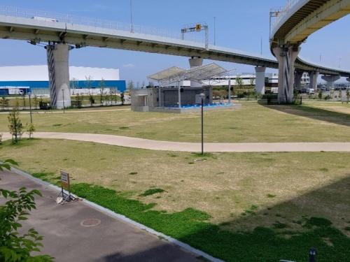 an empty park with a bridge in the background at REF Kansai Airport by VESSEL HOTELS in Izumi-Sano