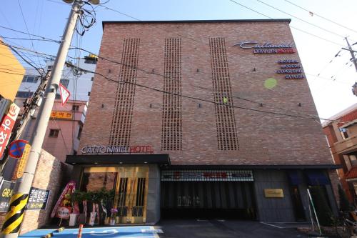 a brick building with a sign on the side of it at Calton Hill Hotel in Jeonju