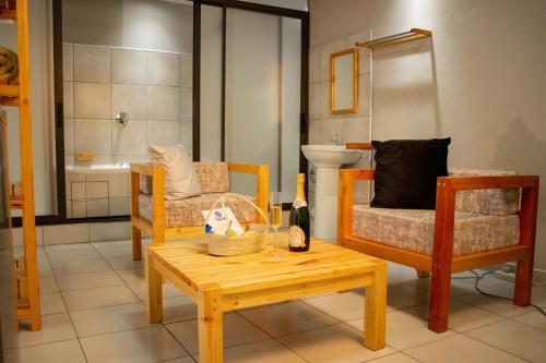 uma sala de estar com uma mesa, uma cadeira e uma banheira em Thabeng Hotel & Restaurant em Maseru