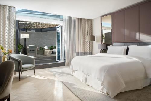 a bedroom with a large white bed and a patio at The St. Regis Mexico City in Mexico City