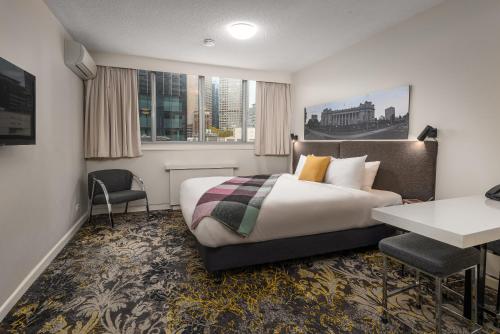 Habitación de hotel con cama y escritorio en City Limits Hotel Apartments, en Melbourne