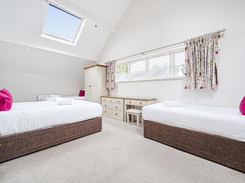 - 2 lits dans une chambre avec 2 fenêtres dans l'établissement Hazel - Woodland Cottages, à Bowness-on-Windermere