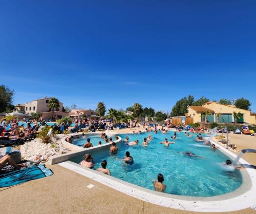 un groupe de personnes dans une piscine d'un complexe hôtelier dans l'établissement Mobil-home à valras-plage au Camping les sables du Midi, à Sérignan