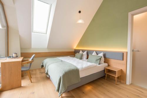 a bedroom with a bed and a desk and a window at Naturparkbauernhof Pöltl in Pöllau