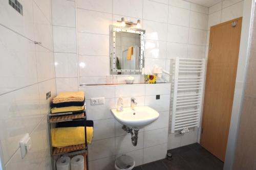 a white bathroom with a sink and a mirror at Gästehaus Dürnberg in Pastetten