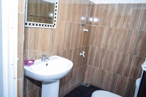 a bathroom with a sink and a toilet and a mirror at The Emerald Guest House & Villa in Unawatuna