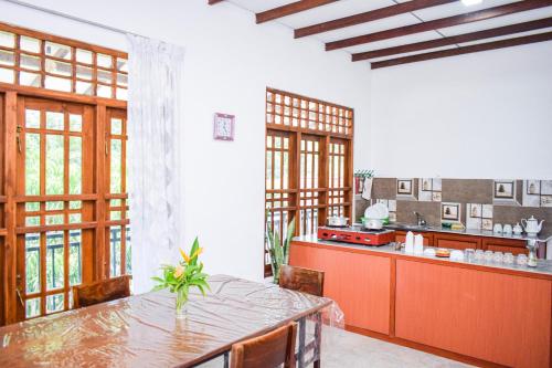 a large kitchen with a table and a counter at The Emerald Guest House & Villa in Unawatuna