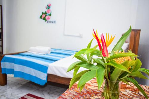 a room with a table with a vase with a plant at The Emerald Guest House & Villa in Unawatuna