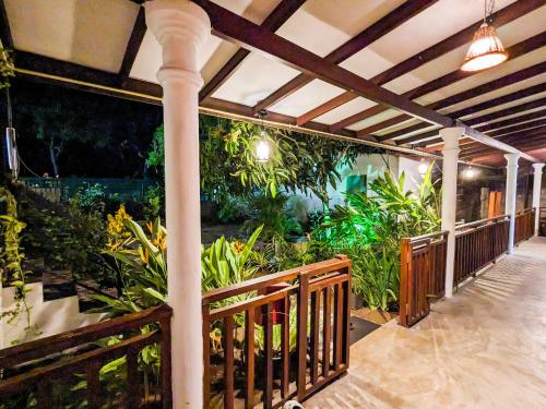 a porch with a wooden fence and plants at The Emerald Guest House & Villa in Unawatuna