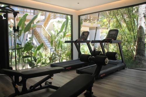 a gym with three treadmills in front of a window at ANGKLA Beach Club & Boutique Resort in El Nido