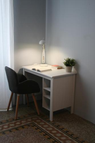 escritorio con silla, lámpara y planta en sauro 56 camera azzurra, en La Spezia