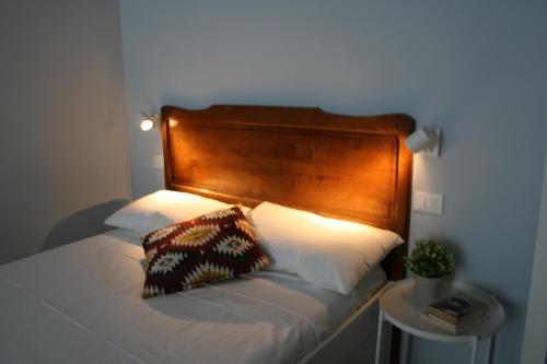1 cama con cabecero de madera y almohada en sauro 56 camera azzurra, en La Spezia