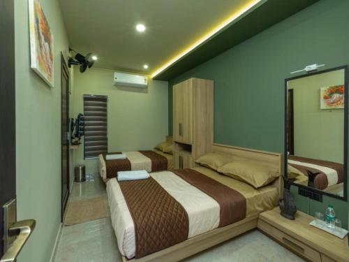 a bedroom with two beds and a mirror at NIDRA INN in Kozhikode