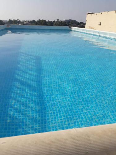 a large swimming pool with blue water at A room in Luqa in Luqa