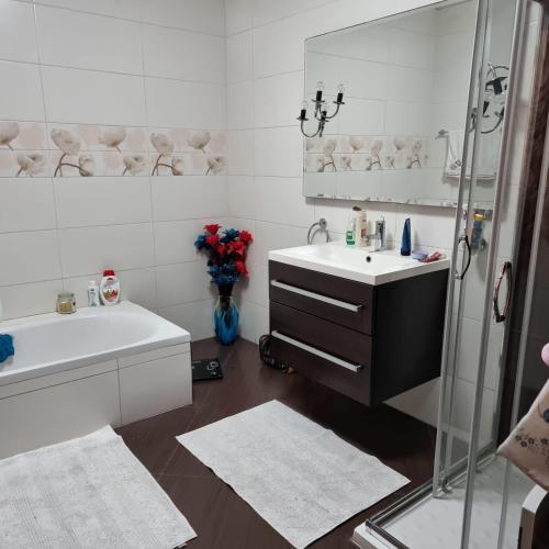 uma casa de banho branca com um lavatório e um chuveiro em A room in Luqa em Luqa