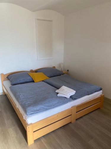 ein Bett mit einem Holzrahmen in einem Schlafzimmer in der Unterkunft Na domečku in Bořetice