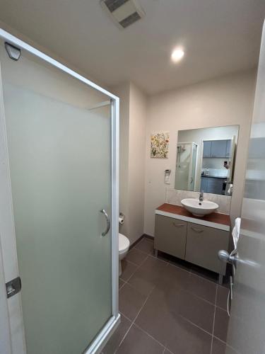a bathroom with a shower and a sink and a toilet at City Garden Penthouse in Auckland