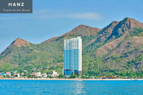 a tall building on the shore of a body of water at HANZ Muong Thanh Vien Trieu Condo Hotel in Nha Trang