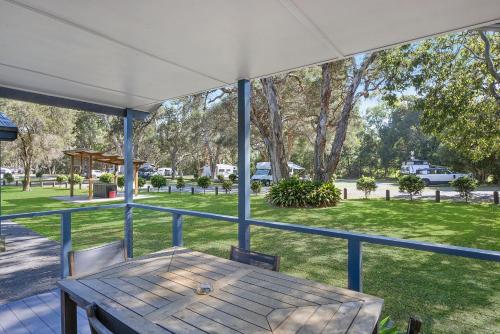 a porch with a wooden table and a view of a park at Reflections North Haven - Holiday Park in North Haven