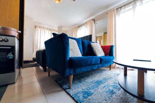 uma sala de estar com um sofá azul e uma mesa em Studio Nairobi Mvuli em Nairobi