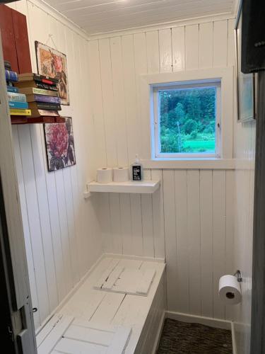 a small bathroom with a sink and a window at Riverside Bliss - Cozy Cabin near Tvedestrand with WiFi and Deck in Vegårshei