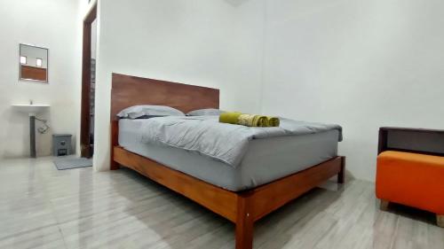 um quarto com uma cama e uma cabeceira em madeira em Angin Mamiri Rinjani Cottages And Restaurant em Senaru
