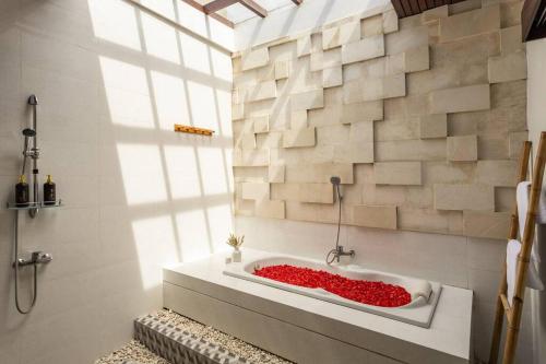 y baño con bañera con flores rojas. en Comfy 3bd Family Villa with Private Pool in Central Location, en Kerobokan