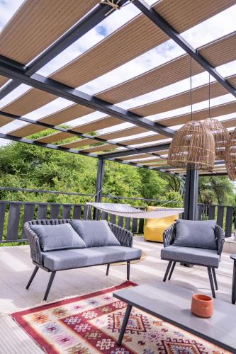 a patio with two couches on a deck with a pergola at Elephant lodge in Kwa Kuchinia
